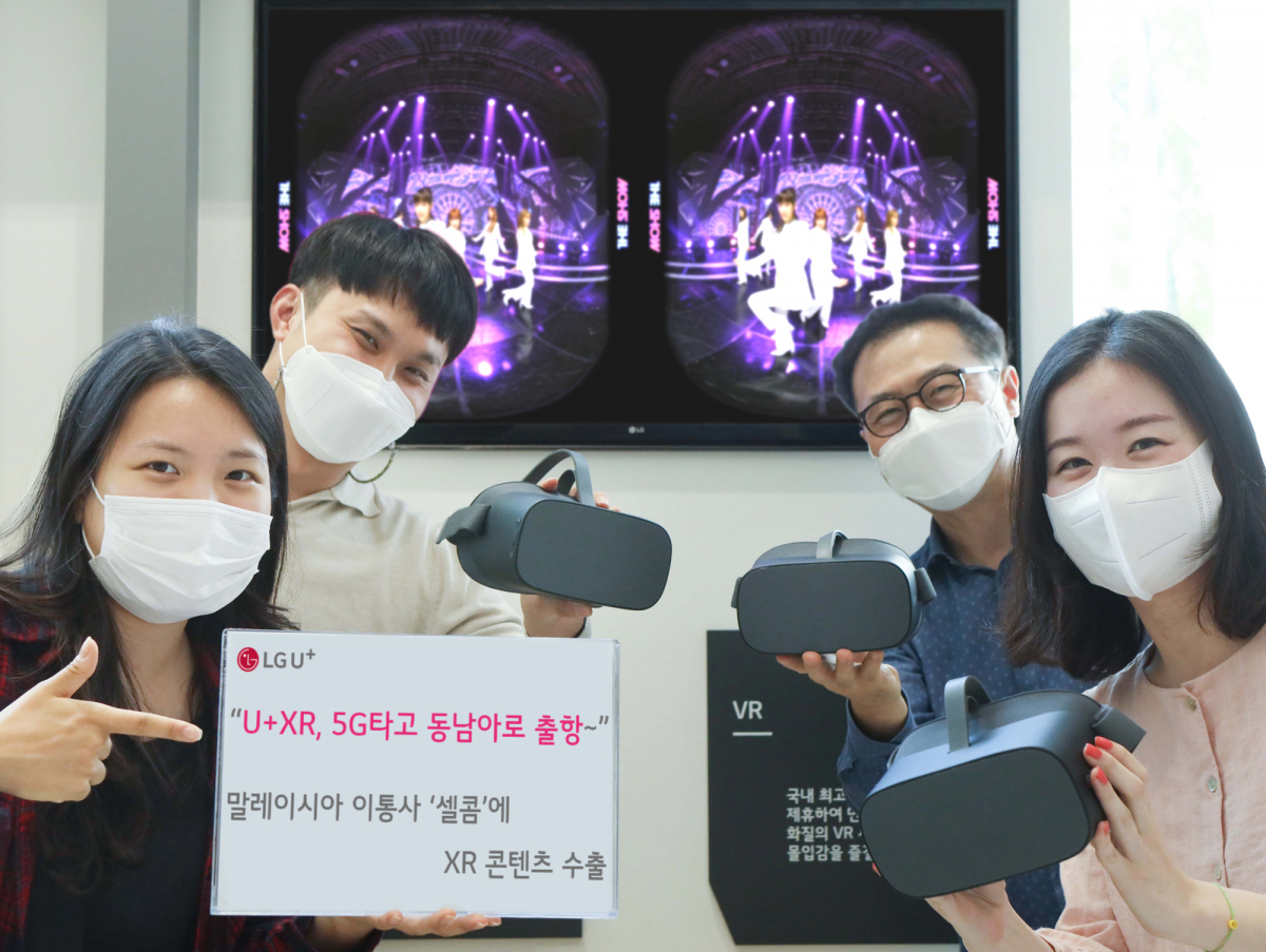 ▲LG유플러스는 말레이시아의 이동통신사 셀콤 악시아타 베르하드와 5G 기반의 XR 콘텐츠 수출 계약을 체결했다고 20일 밝혔다. LG유플러스 XR사업기획팀 구성원들이 셀콤 측에 수출한 VR 콘텐츠와 함께 수출 계약을 알리고 있다. (사진제공=LG유플러스)