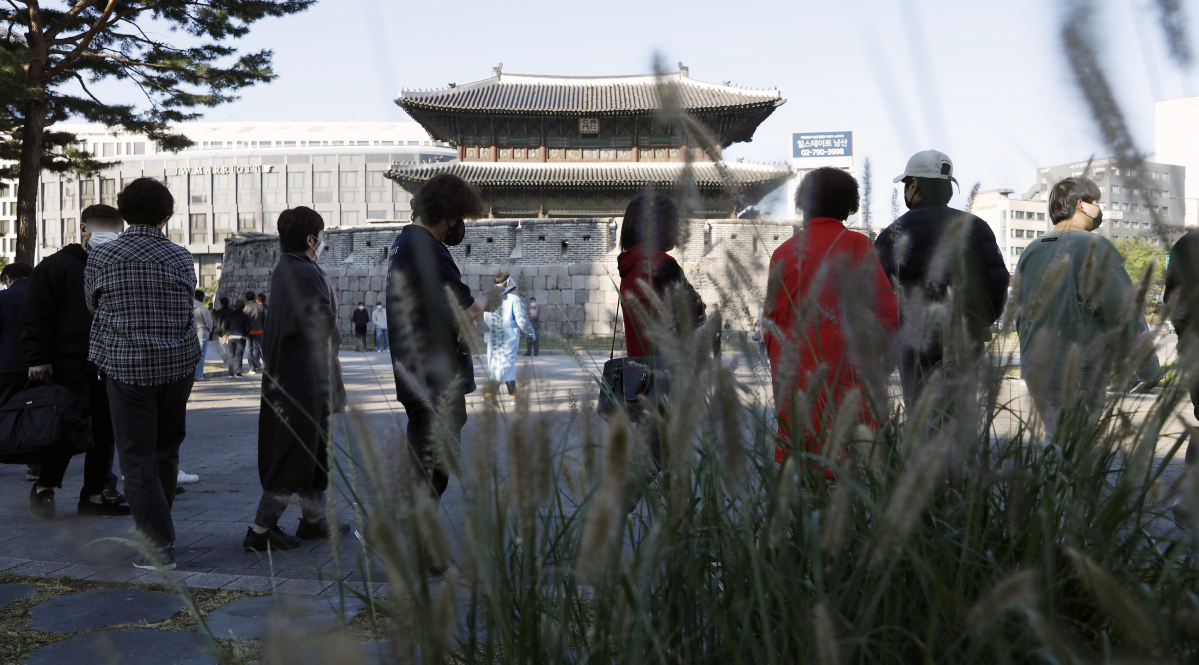 ▲동대문종합시장에서 코로나19 집단감염이 발생한 이튿날인 20일 서울 흥인지문 옆에 설치된 서울시 찾아가는 선별진료소를 찾은 상인 등 시민들이 검사를 받기 위해 줄을 서고 있다. (뉴시스)