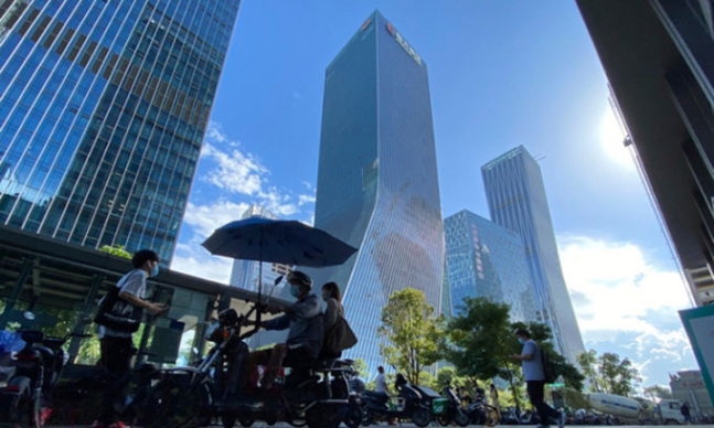 ▲중국 남부 선전(深?)에 있는 중국 부동산개발회사 헝다(에버그란데) 그룹 본사 앞을 주민들이 지나가고 있다. (선전=AP뉴시스)