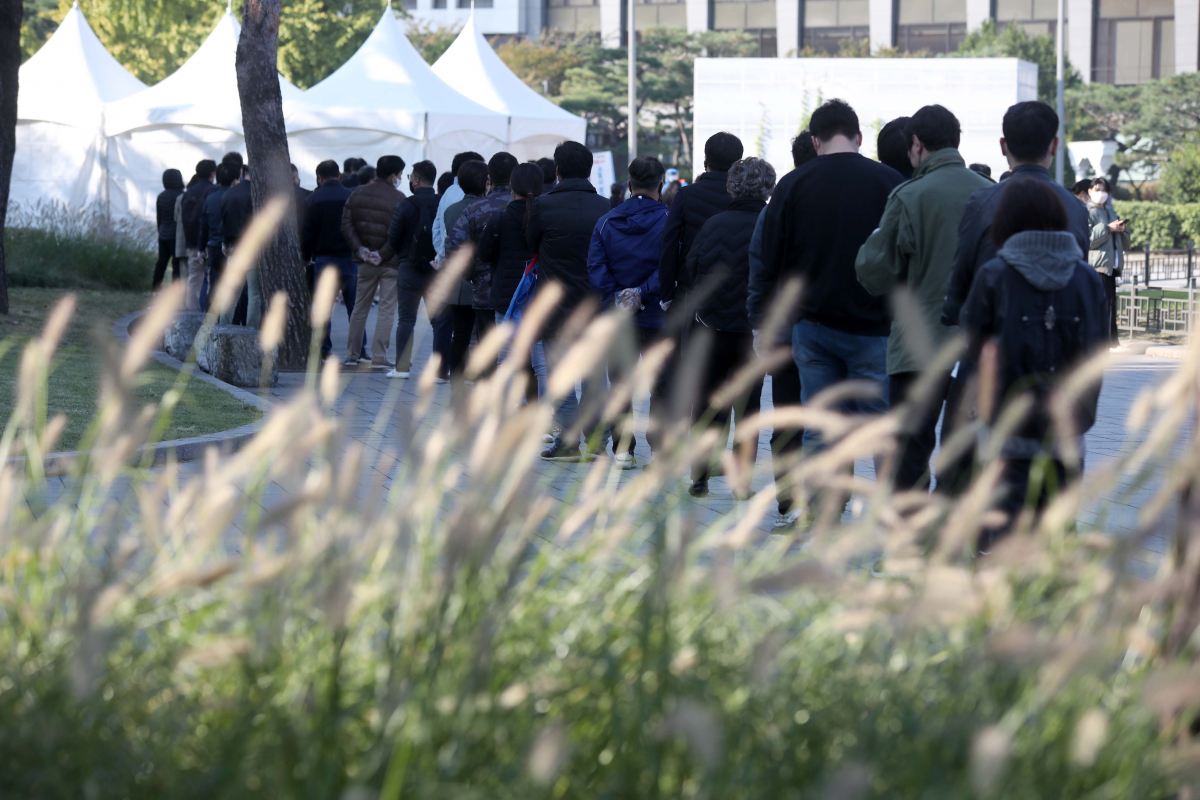 ▲0시 기준 1440명의 신규 코로나19 확진자가 발생한 22일 오전 서울 종로구 흥인지문(동대문) 인근에 설치된 선별진료소에서 시민들이 검사를 받기 위해 줄을 서고 있다. (뉴시스)