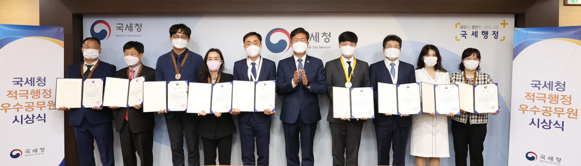 ▲국세청이 25일 정부세종2청사에서 2021년 제3차 적극 행정 우수 공무원을 선발해 표창했다. 왼쪽부터 김제봉 조사관, 남정근 조사관, 김상린 조사관, 나송현 조사관, 한세희 조사관, 김대지 국세청장, 권준경 조사관, 정준모 조사관, 김미희 조사관, 김영숙 조사관. (뉴시스)
