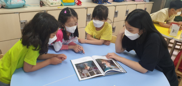 ▲강빛중(사진 오른쪽)학생이 강빛초학생들에게 책을 읽어주고 있다.  (강빛초중이음학교)