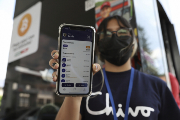 ▲정부 공인 디지털 지갑인 '치보'(Chivo)를 통해 비트코인 결제를 진행하고 있는 엘살바도르 현지 주유소 직원 (뉴시스)
