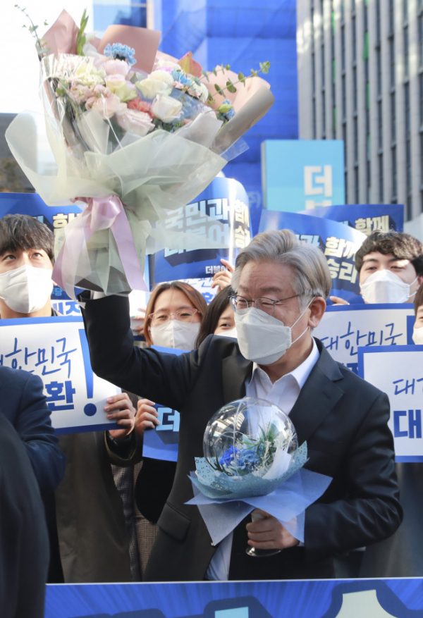 ▲더불어민주당 이재명 대선 후보가 2021년 10월 27일 오후 서울 여의도 당사에서 당직자로 부터 받은 꽃다발을 들어보이고 있다. (연합뉴스)