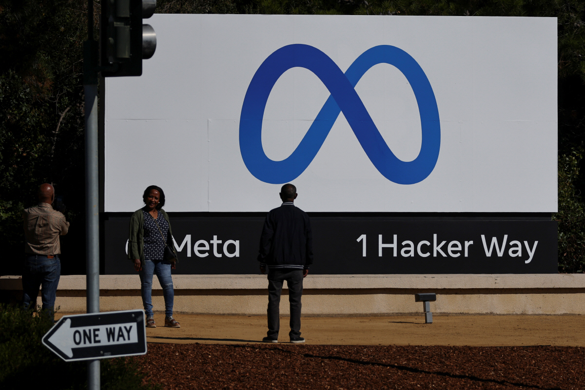 ▲지난달 28일(현지시간) 미국 캘리포니아주 멘로파크의 옛 페이스북 본사 앞에서 ‘메타’(Meta)로 바뀐 회사명과 새 로고가 새겨진 간판을 배경으로 한 여성이 포즈를 취하고 있다. 멘로파크/로이터연합뉴스