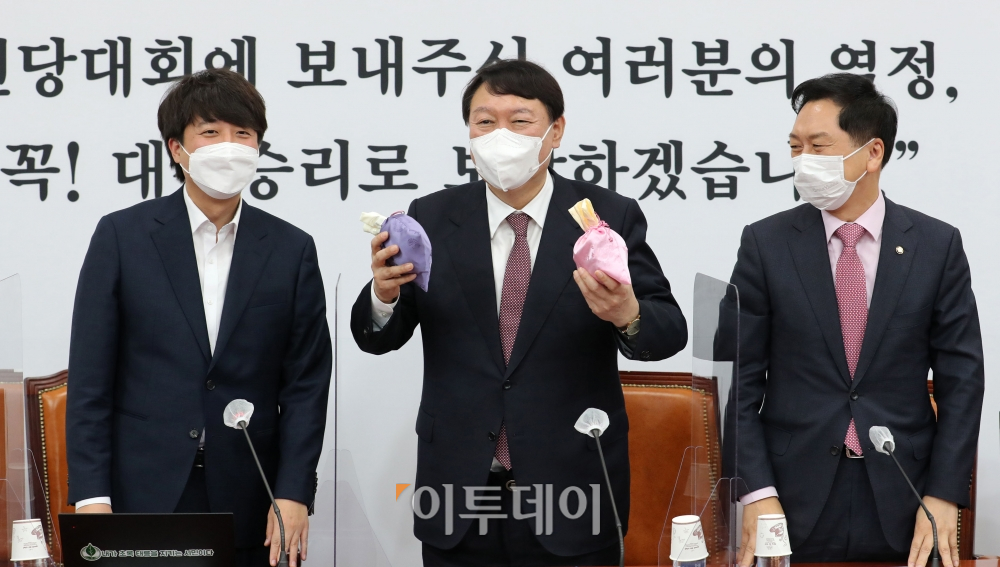 ▲8일 서울 여의도 국회에서 열린 국민의힘 최고위원회의에 참석한 이준석 대표가 당 대선후보인 윤석열 후보에게 '선거에 도움이 된다'는 복주머니를 전달하고 있다. (신태현 기자 holjjak@)