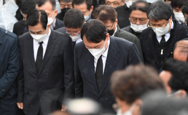 ▲10일 광주 국립 5·18 민주묘지를 찾은 국민의힘 윤석열 대선 후보가 방문을 반대하는 시민들에 막혀 묘역 근처에서 참배를 하면서 묵념을 하고 있다. (공동취재)