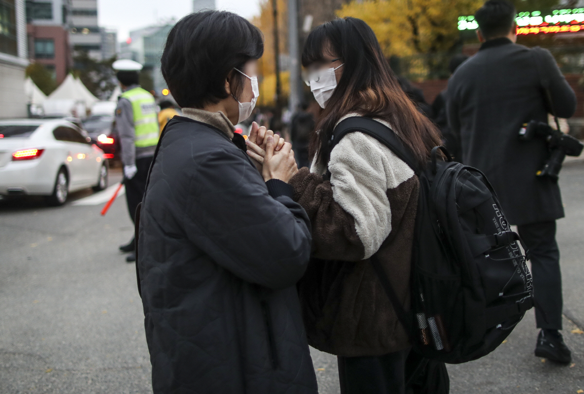 ▲2022학년도 대학수학능력시험일인 18일 오전 서울 서대문구 이화여자외국어고등학교에서 수험생이 어머니의 응원을 받고 있다. (뉴시스)