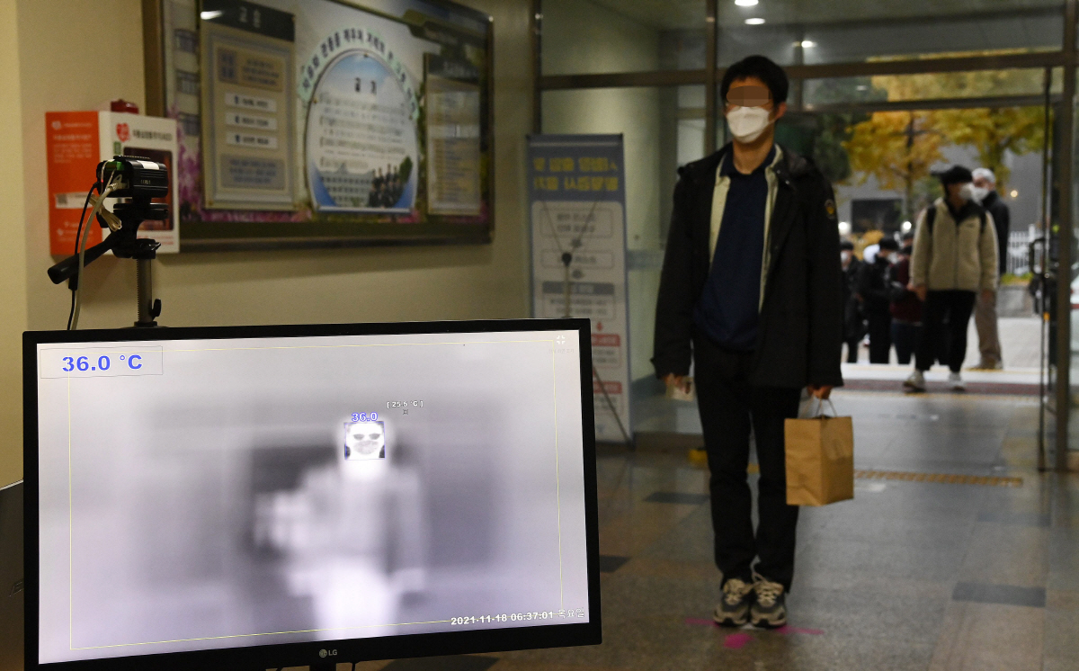 ▲2022학년도 대학수학능력시험이 치러진 18일 서울 용산구 용산고등학교에서 수험생들이 손 소독과 체온측정 등 코로나19 방역 절차를 거친 뒤 시험장에 입실하고 있다. (뉴시스)