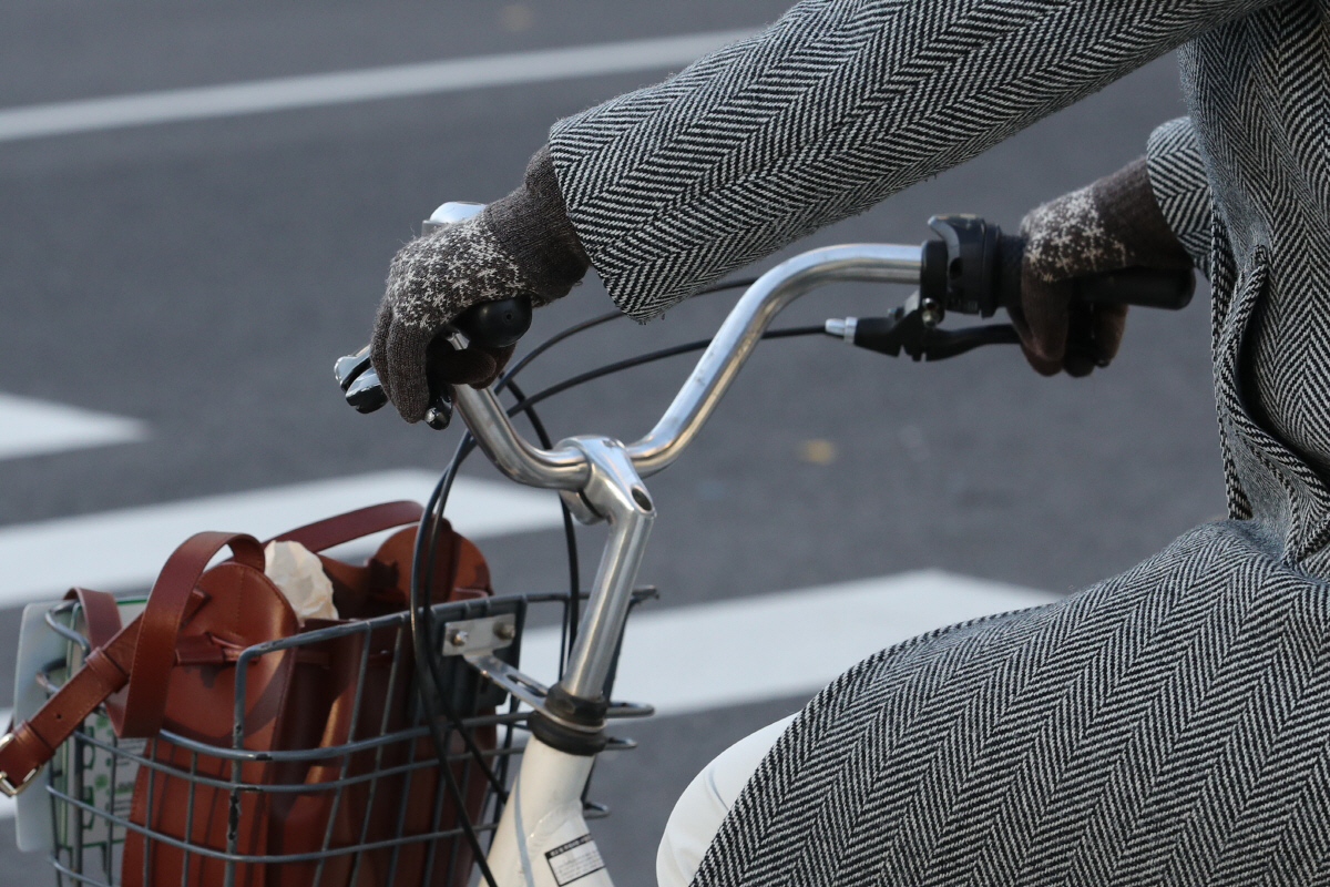 ▲(뉴시스) 12일 오전 서울 종로구 광화문 네거리 인근에서 직장인이 장갑을 끼고 따릉이를 타며 출근하고 있다.