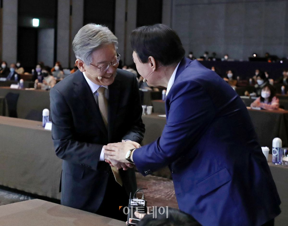 ▲22일 오전 서울 광진구 그랜드 워커힐 서울에서 열린 TV조선 글로벌리더스포럼2021에 참석한 이재명 더불어민주당 대선 후보와 윤석열 국민의힘 대선 후보가 인사를 나누고 있다. (국회사진취재단)