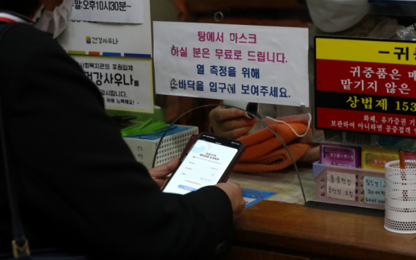 ▲2일 오전 서울 시내 목욕탕에서 이용객이 접종증명서를 보여주는 모습.  (뉴시스)