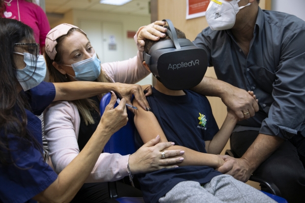 ▲이스라엘 라마트간의 한 병원에서 22일 8세 어린이가 가상현실(VR) 고글을 착용한 채 화이자 백신을 맞고 있다. 라마트간/AP연합뉴스