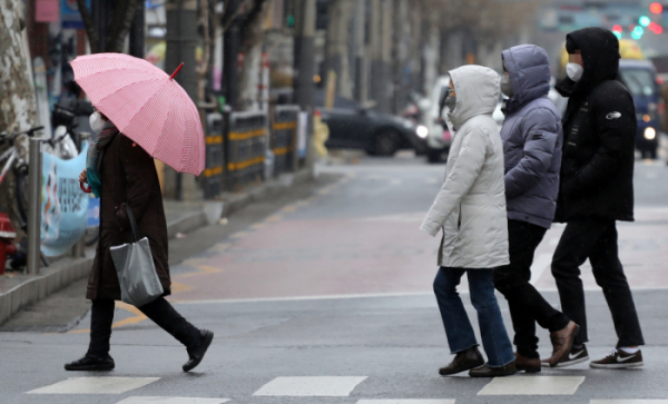 ▲겨울비가 내린 21일 서울 시내에서 한 시민이 우산을 쓰고 있다. 우산이 없는 사람들은 모자를 썼다.  (연합뉴스)