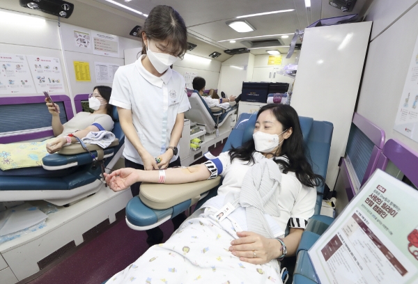 ▲KT 광화문원팀 소속 임직원이 대한적십자사 헌혈버스에서 헌혈을 하고 있다. (사진제공=KT)