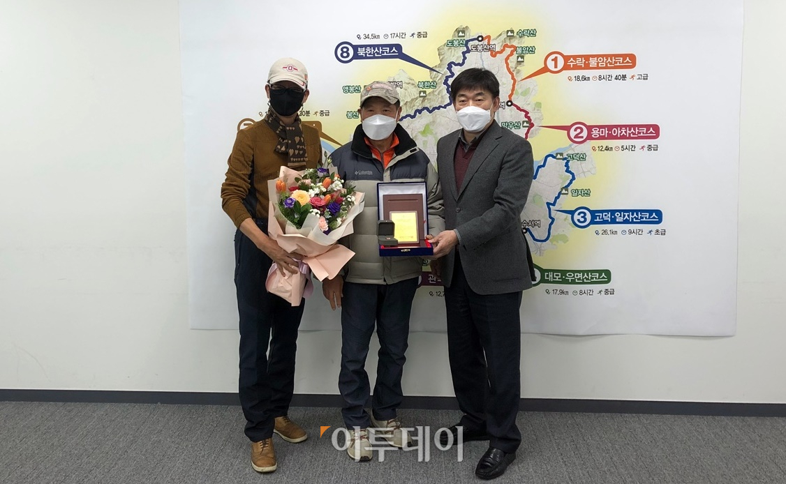 ▲김충근 씨(가운데)가 3일 서울 중구 서울서소문로2청사에서 열린 5만 번째 완주자 기념행사에서 기념품을 받고 있다. (홍인석 기자 mystic@)