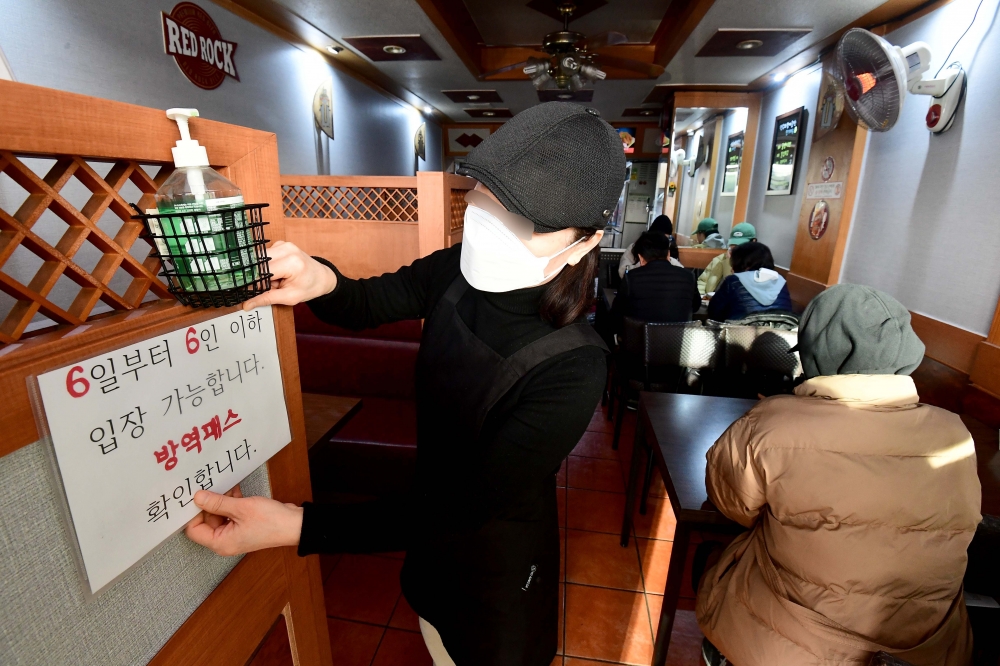 ▲5일 서울의 한 호프집에서 관계자가 사적모임 인원제한 문구를 게시하고 있다. (신태현 기자 holjjak@)