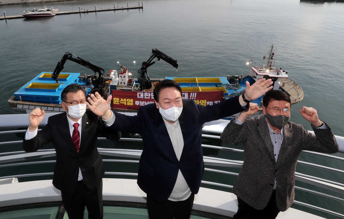 ▲윤석열 국민의힘 대선 후보가 11일 강원도 속초 대포항 다리에 올라 어민들의 환영 현수막을 보며 손 흔들어 인사하고 있다. (공동취재사진단)