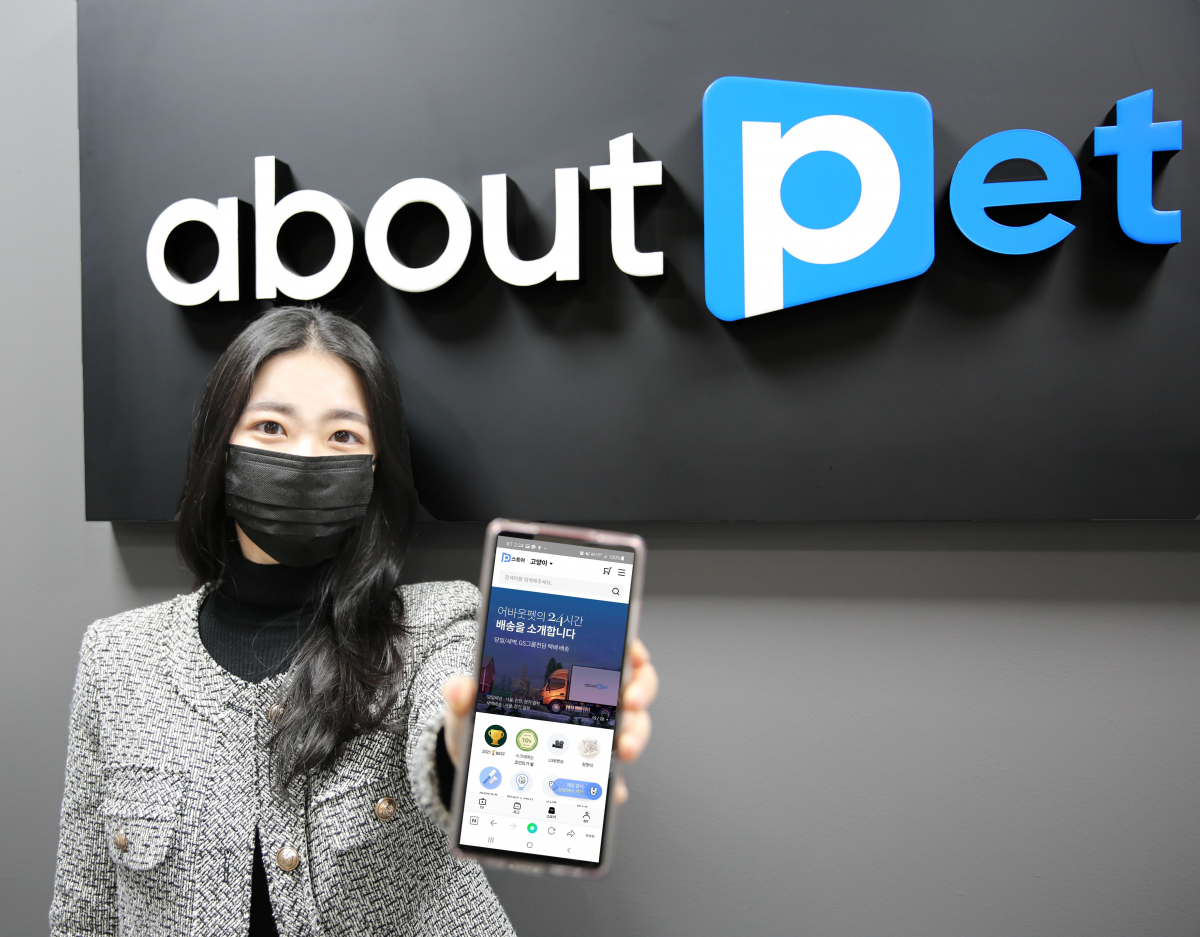 ▲모델이 어바웃펫 쇼핑몰 화면이 나온 스마트폰을 들고 포즈를 취하고 있다.  (사진제공=GS리테일)