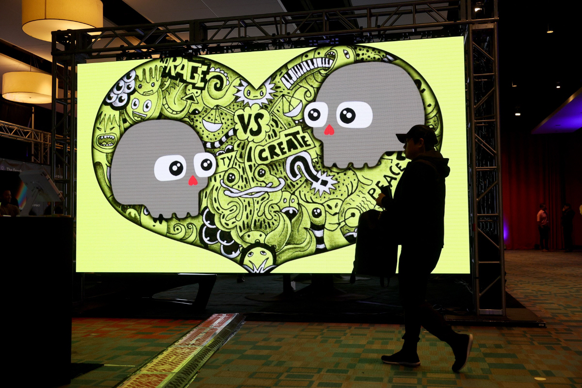 ▲한 행인이 11월 미국 마이애미 공항 컨벤션 센터에서 열린 노운오리진(KnownOrigin) 행사장을 걸어가고 있다. 노운오리진은 이더리움 기반 아트 플랫폼 중 하나다. 마이애미/AFP연합뉴스