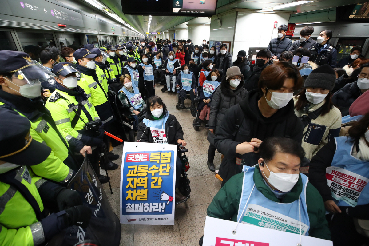 ▲전국장애인차별철폐연대 관계자들이 지난해 12월 20일 오전 서울 지하철 5호선 광화문역에서 열차에 탑승해 장애인 이동권 보장을 촉구하는 피케팅을 하고 있다. (연합뉴스)