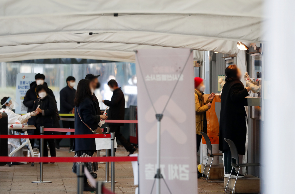 ▲0시 기준 코로나19 신규 확진자가 5202명으로 집계된 21일 오전 서울시청 앞 서울광장 임시선별검사소에서 시민들이 검사를 받고 있다. (뉴시스)