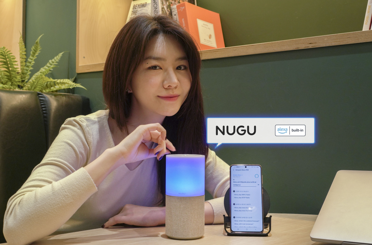 ▲SKT 홍보 모델이 ‘누구 캔들’에서 ‘Alexa’가 탑재된 ‘누구 멀티 에이전트’ 서비스를 시연하고 있다.  (사진제공=SK텔레콤)