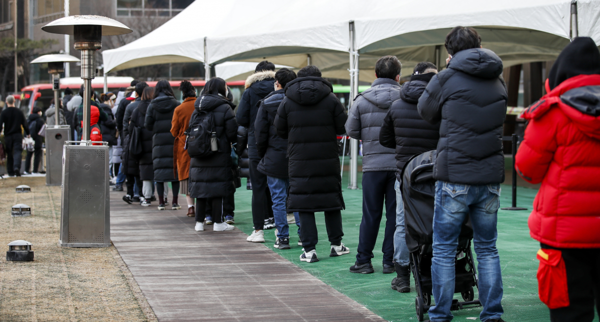 ▲0시 기준 코로나19 신규 확진자가 6919명으로 집계된 23일 오전 서울 송파구보건소 코로나19 선별진료소를 찾은 시민들이 검사를 받기 위해 줄 서 있다. (뉴시스)