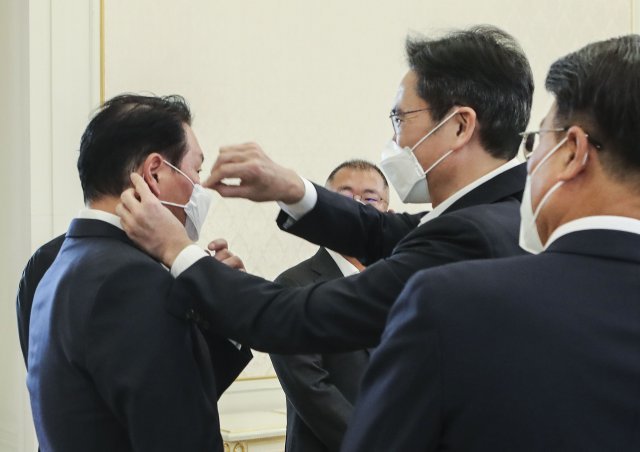▲이재용 삼성전자 부회장이 27일 청와대에서 열린 ‘청년희망온(ON)’에 참여한 대기업 대표들과 오찬 간담회 시작 전 최태원 SK 회장의 X자로 엇갈린 마스크 끈을 고쳐주고 있다.  (청와대사진기자단)