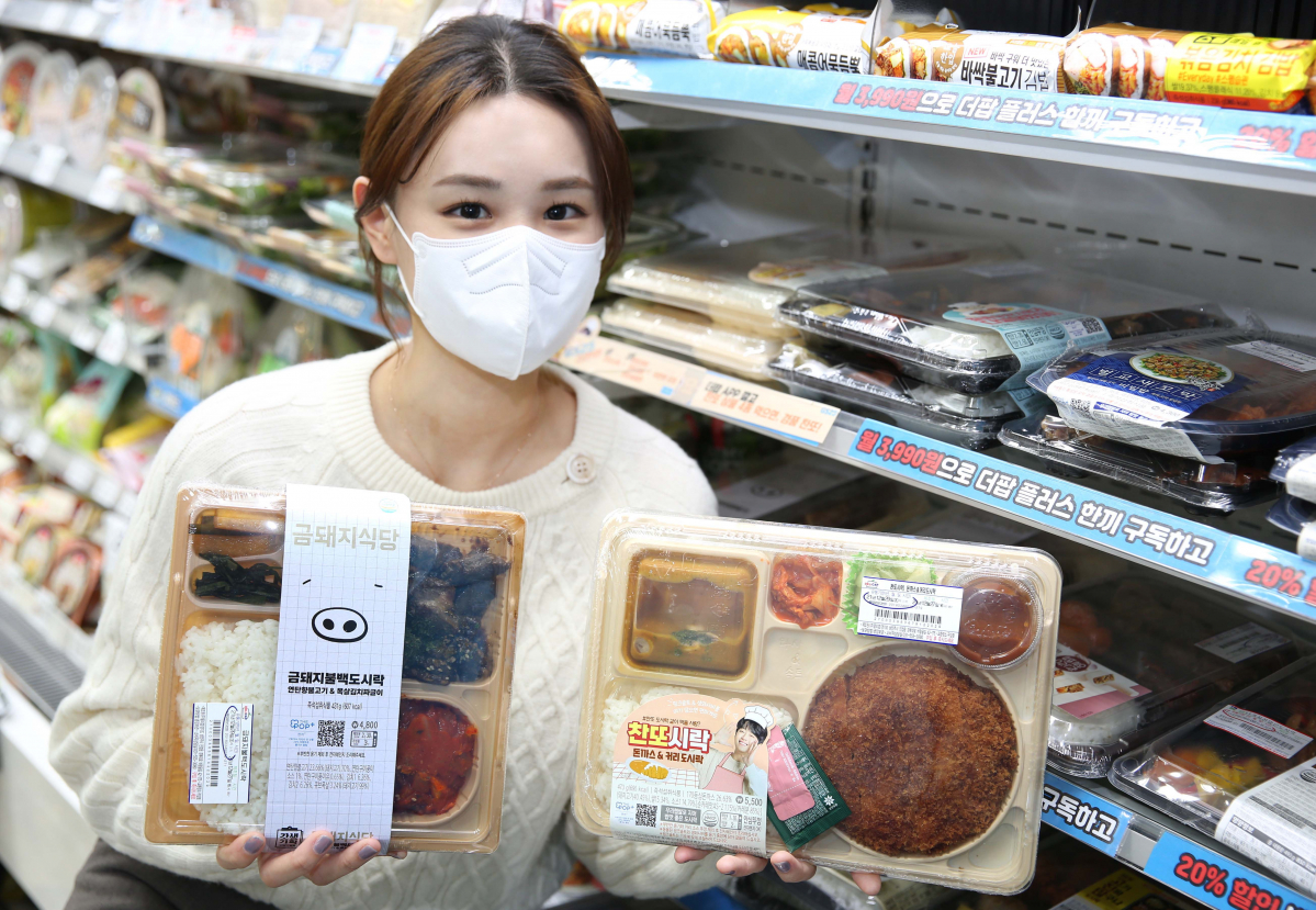 ▲GS25 매장에서 모델이 금돼지식당 및 이찬원과 콜라보한 도시락 상품을 들고 포즈를 취하고 있다. (사진제공=GS25)