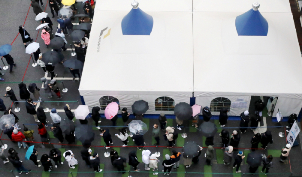 ▲코로나19 신규 확진자수가 7850명으로 역대 최다를 기록한 15일 오전 서울 강남구보건소 선별진료소에서 우산을 쓴 시민들이 코로나19 검사를 받기 위해 길게 줄 서 있다.  (뉴시스)