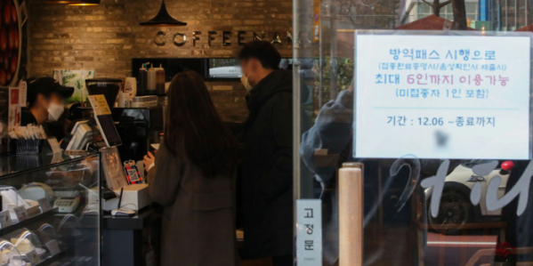 ▲코로나19 확산세로 '단계적 일상회복(위드코로나)'이 중단되고 방역패스가 도입된 가운데 7일 오후 서울 시내 한 카페에서 카페 점주가 방역패스를 확인하고 있다. (뉴시스)
