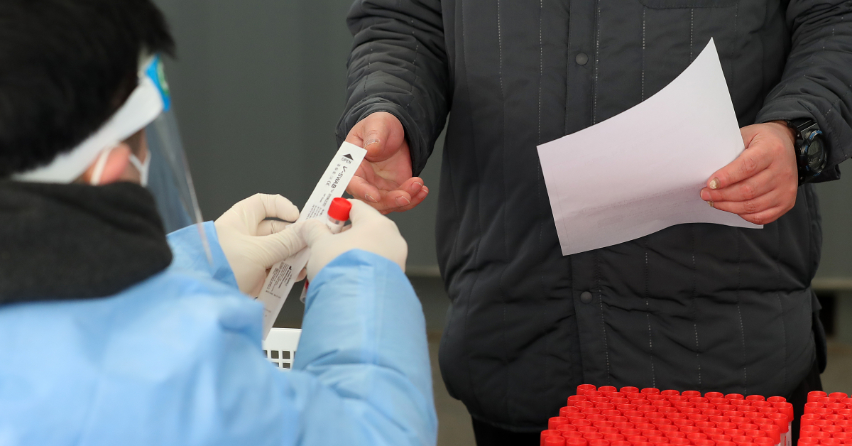 ▲임인년 (壬寅年) 새해 첫날인 1일 오전 서울 중구 서울역광장에 마련된 코로나19 임시선별검사소에서 한 시민이 검진키트를 받고 있다.  (뉴시스)