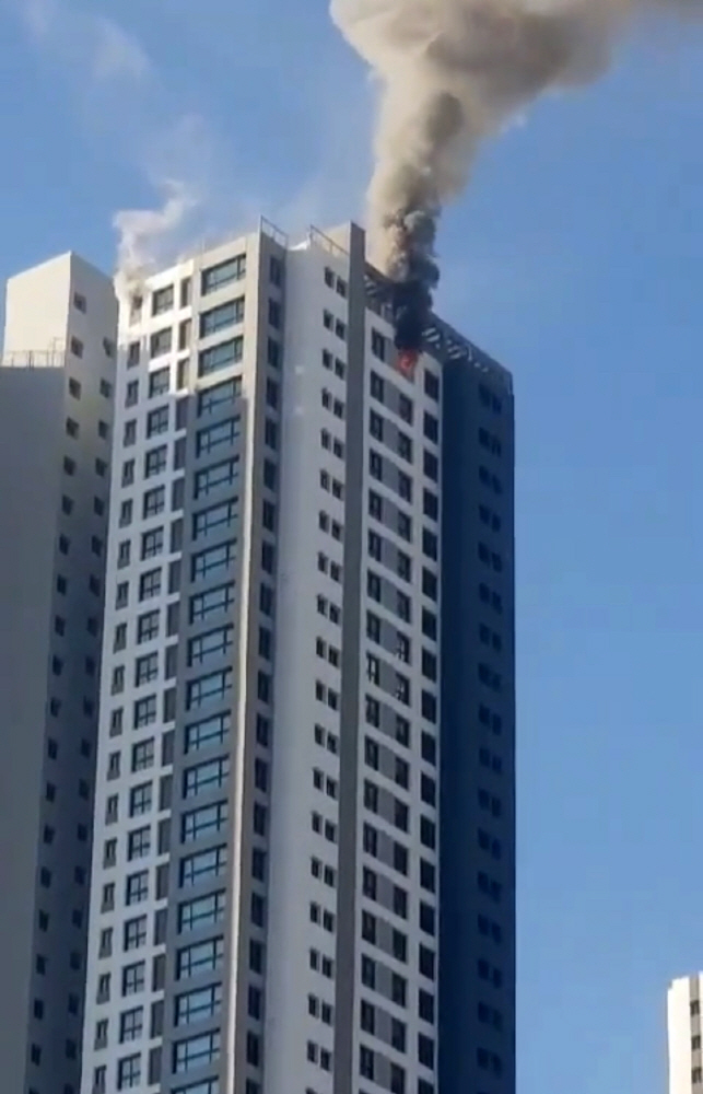 ▲12일 오전 9시 40분께 강원 춘천시 온의동의 신축 공사 중인 아파트 49층에서 불이 나 검은 연기가 치솟고 있다. (연합뉴스)