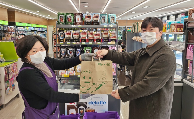 ▲CU제주그랜드조선호텔점에서 직원이 고객에게 친환경 종이봉투로 상품을 전달하고 있다.  (사진제공=CU)