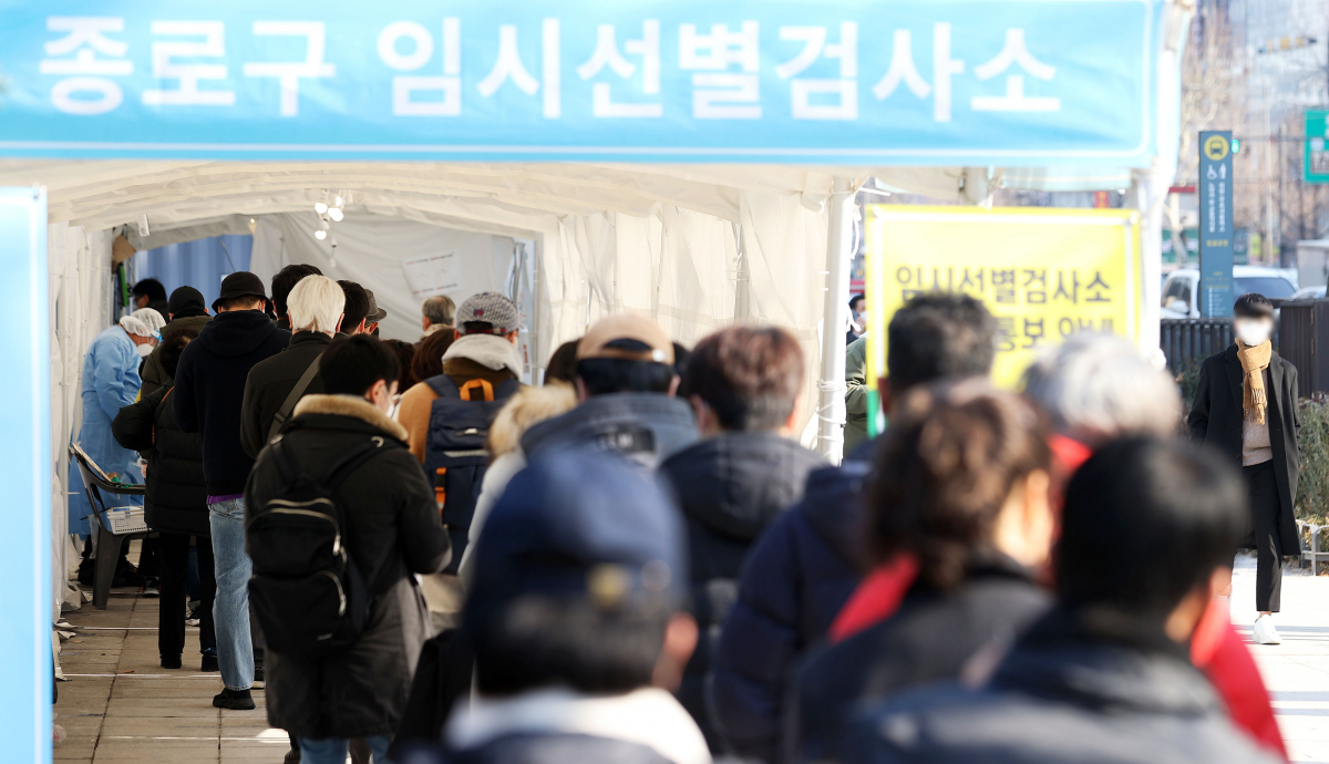 ▲0시 기준 코로나19 신규 확진자가 7009명으로 집계된 22일 서울 종로구 탑골공원 삼일문 임시선별검사소를 찾은 시민들이 검사를 받기 위해 대기하고 있다.  (뉴시스)