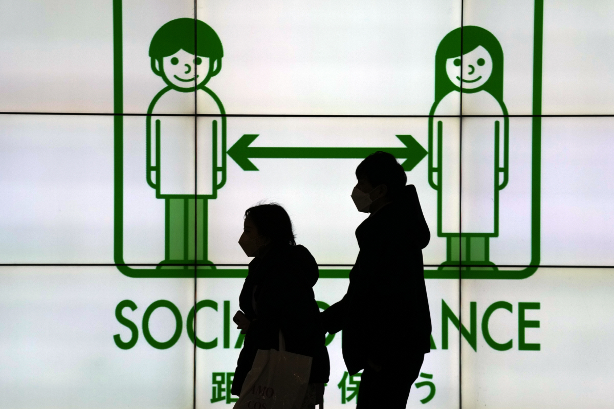 ▲일본 도쿄에서 24일 시민들 뒤로 사회적 거리두기 안내판이 보인다. 도쿄/AP연합뉴스