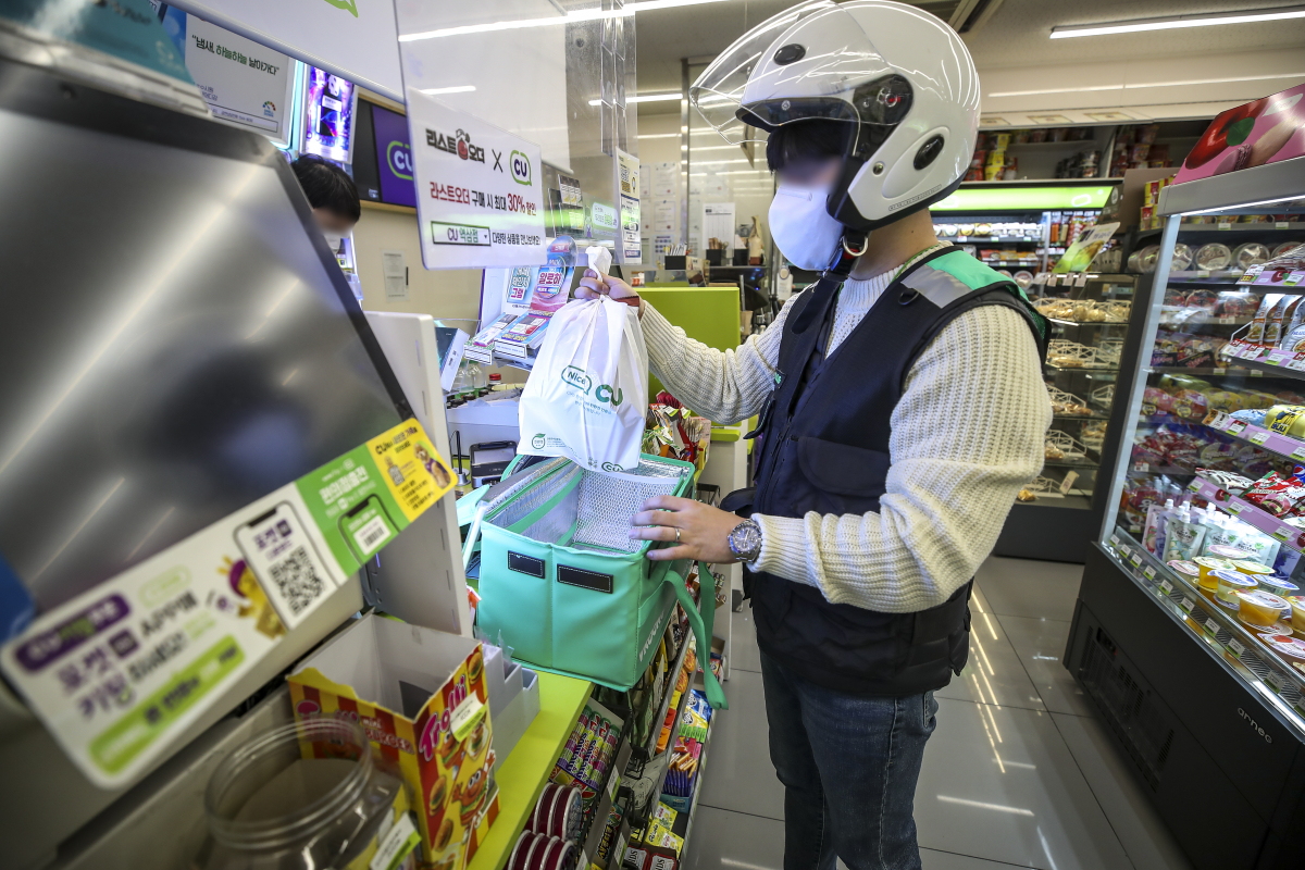 ▲서울시내의 한 편의점에서 배달 아르바이트생이 고객이 주문한 물건을 픽업하고 있다. (뉴시스)
