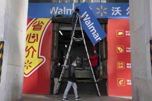 ▲중국 베이징 월마트 매장 앞에서 직원이 간판을 떼고 있다. 베이징/AP뉴시스
