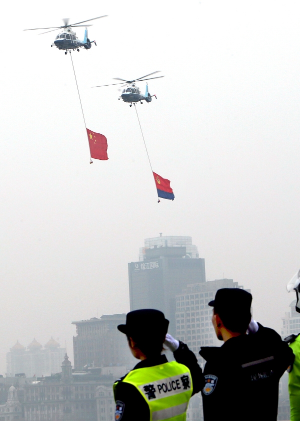 ▲중국 상하이에서 10일 공안들이 헬기에 매달린 국기를 향해 경례하고 있다. 상하이/신화뉴시스
