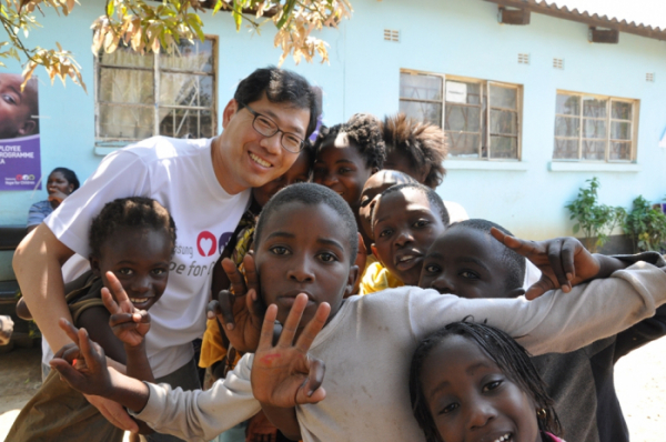 ▲정성수 부산부민병원 의무원장이 잠비아 의료봉사에서 만난 어린이들과 포즈를 취하고 있다. (사진제공=부산부민병원)
