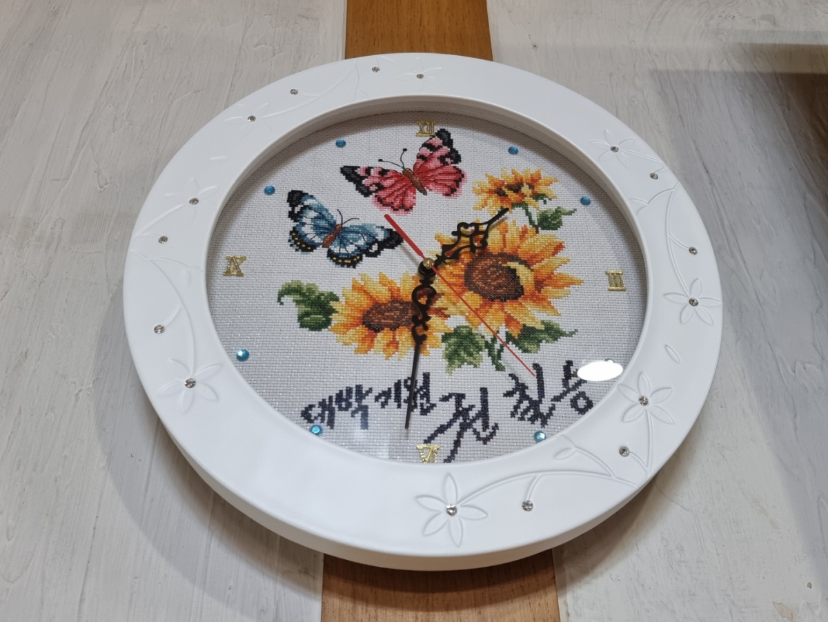 ▲9일 권칠승 장관이 소상공인에게 전달한 해바라기 십자수 그림이 그려져 있는 시계가 가게 벽에 걸려 있다. (심민규 기자 wildboar@)