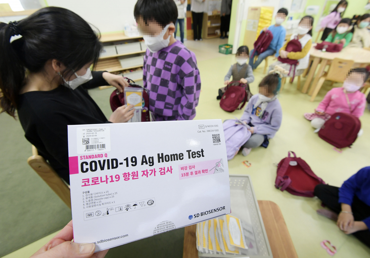 ▲22일 오전 서울 구로구 서울항동유치원에서 한 교사가 유치원생에게 신속항원검사 키트를 배부하고 있다. 교육부는  '오미크론 대응 새 학기 학교 방역 추가 지원 방안'을 발표하면서 유·초·중·고 학생에게 신속항원검사 키트를 배포하고 자택에서 등교 하루 전부터 선제 검사를 하도록 권고했다.  (연합뉴스)