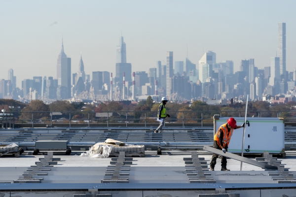 ▲미국 뉴욕 라과르디아공항의 터미널B 창고 옥상에서 지난해 11월 9일 근로자들이 태양광 패널을 설치하고 있다. 뉴욕/AP뉴시스
