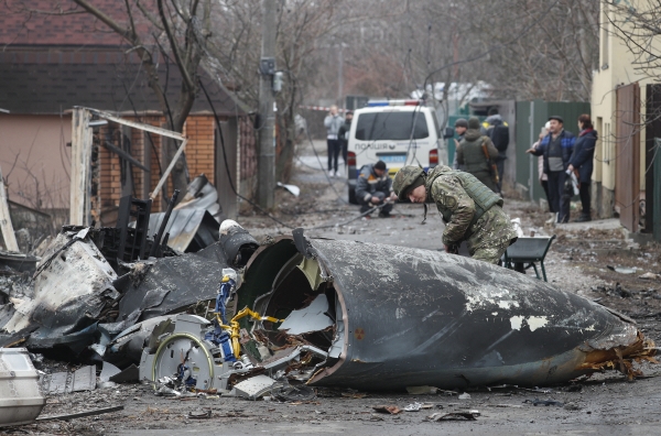 ▲한 우크라이나 군인이 25일(현지시간) 수도 키예프에서 격추된 군용기 잔해를 살펴보고 있다. 키예프/EPA연합뉴스 

