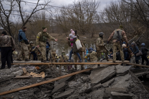 ▲우크라이나 군인들이 러시아군의 공격을 피해 탈출하는 사람들을 돕고 있다. 이르핀/AP연합뉴스
