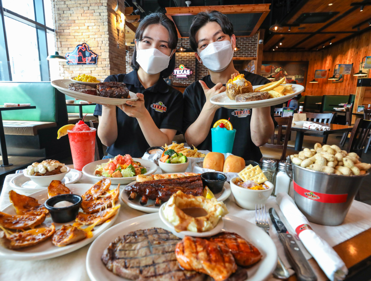 ▲13일 경기도 남양주시에 위치한 현대프리미엄아울렛 스페이스원 1층 텍사스로드하우스에서 직원들이 2인 스페셜 세트를 소개하고 있다. (현대그린푸드)