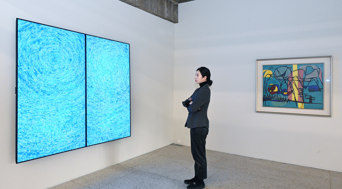 ▲서울 용산구 보광동에 위치한 가나아트 보광에서 김환기 화백의 대표작 '우주'의 NFT 작품을 감상하고 있는 모습 (사진제공=LG전자)