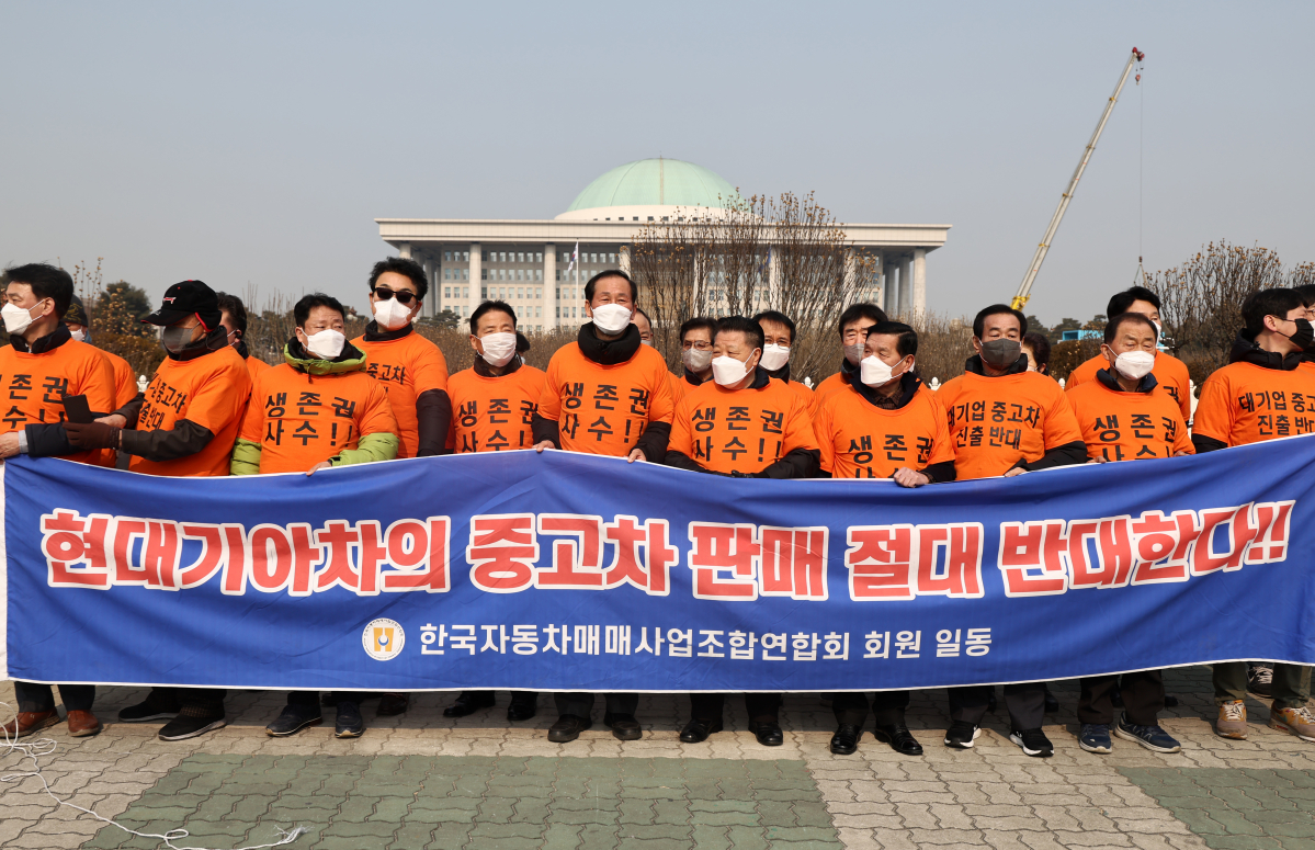 ▲2월 25일 오전 국회 앞에서 한국자동차매매사업조합연합회원들이 현대기아차 중고차시장 진출을 반대하는 내용의 현수막을 들고 있다. (연합뉴스)