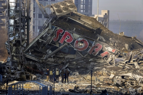 ▲21일(현지시간) 우크라이나 키이우에서 주민들이 러시아군의 포격으로 파괴된 쇼핑몰의 피해 상황을 살피고 있다. 키이우/AP뉴시스 
